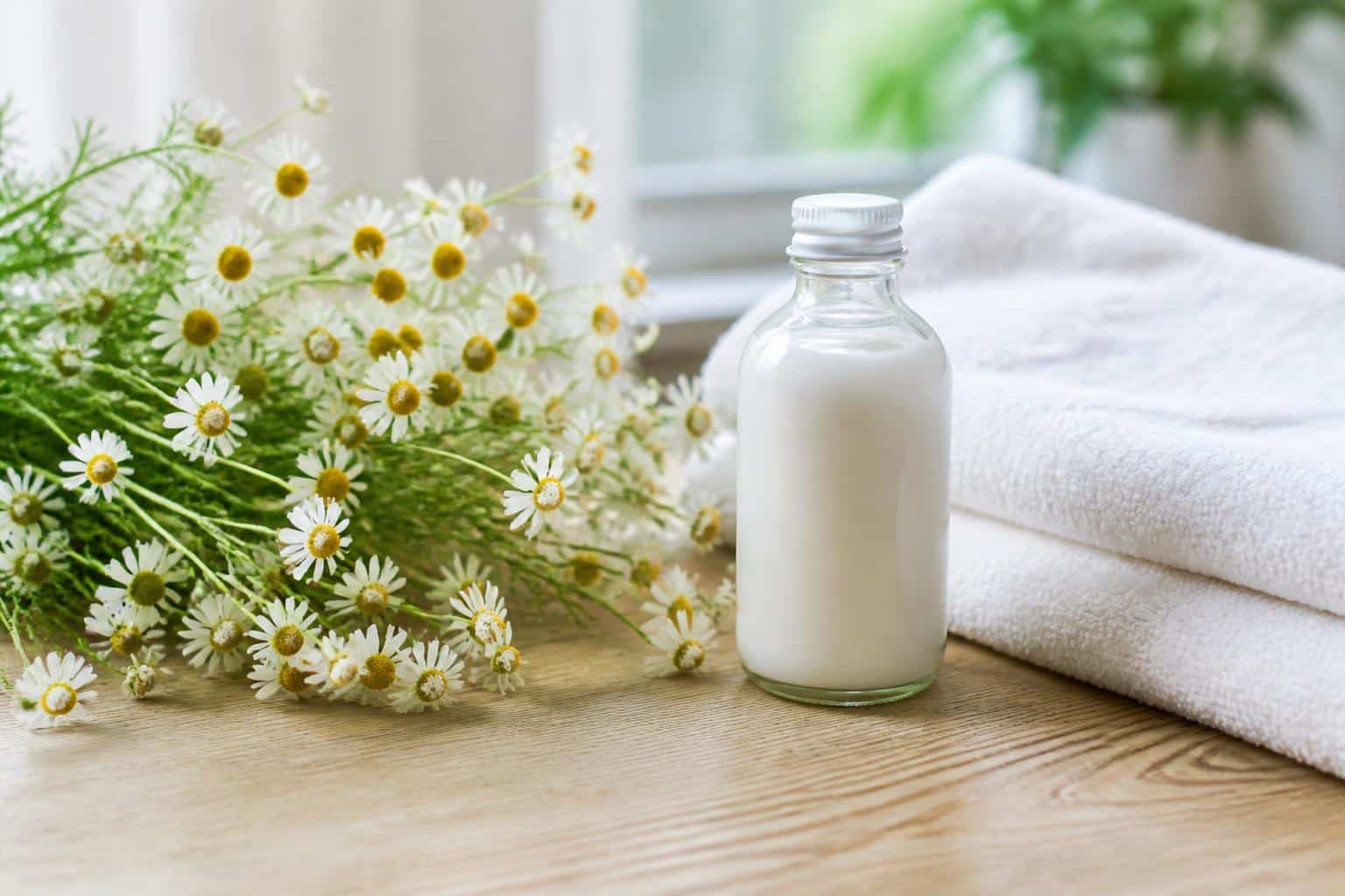 Chamomile flowers, a soft towel, and gentle skincare lotion arranged for comfort care